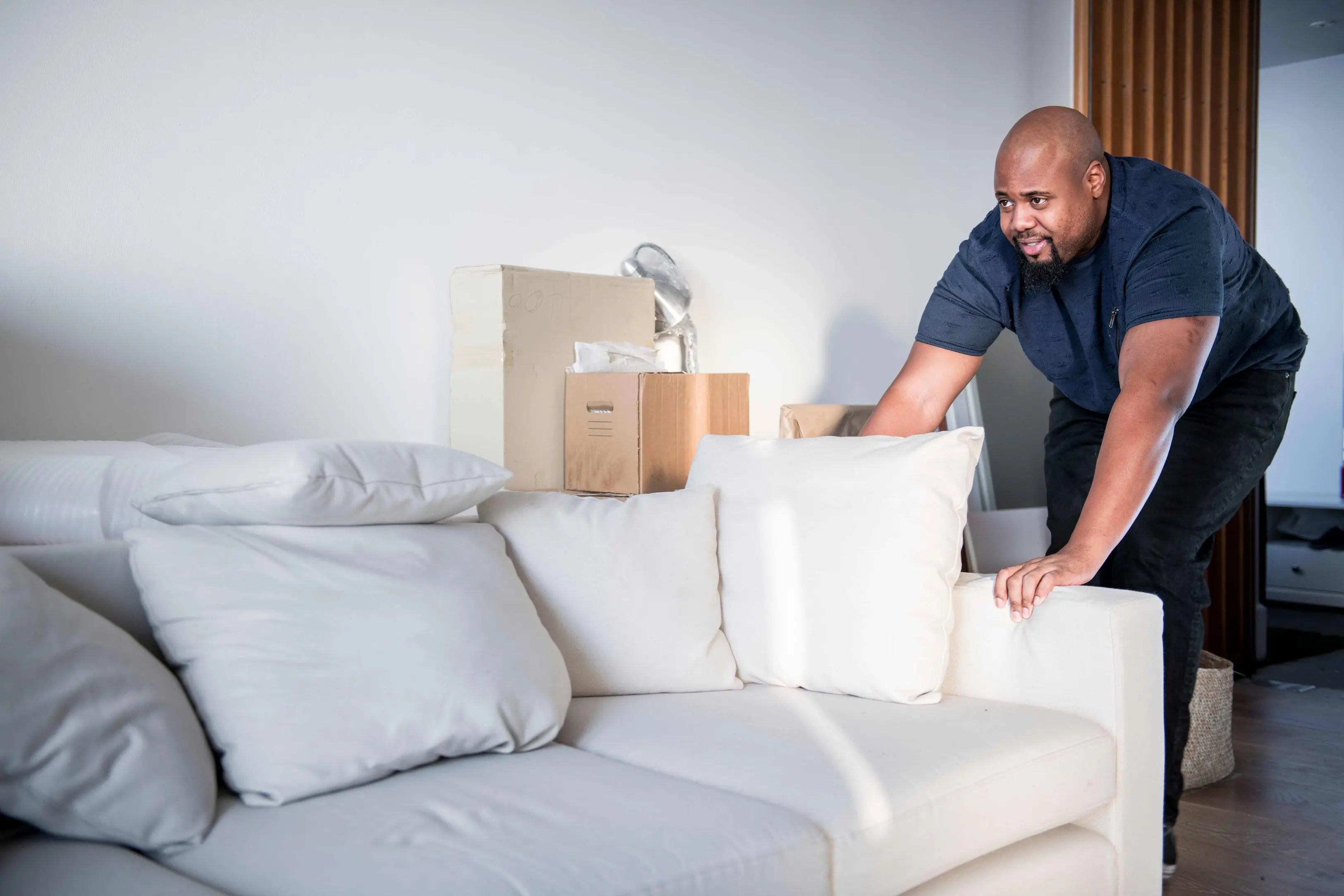 A man slide his couch he want to know how to keep couch from Sliding