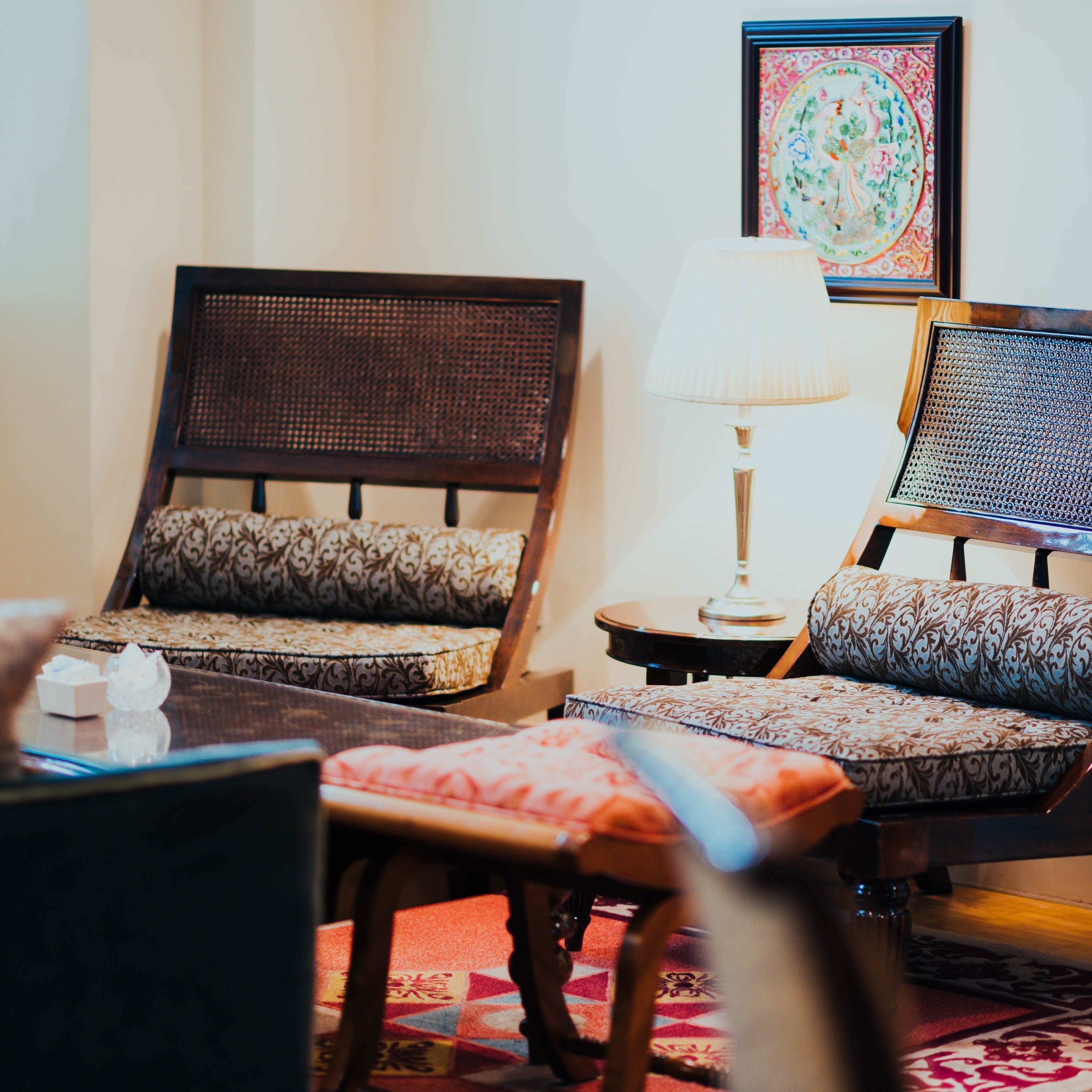 Traditional wooden chairs with matching ottoman footrests in classic living room setup