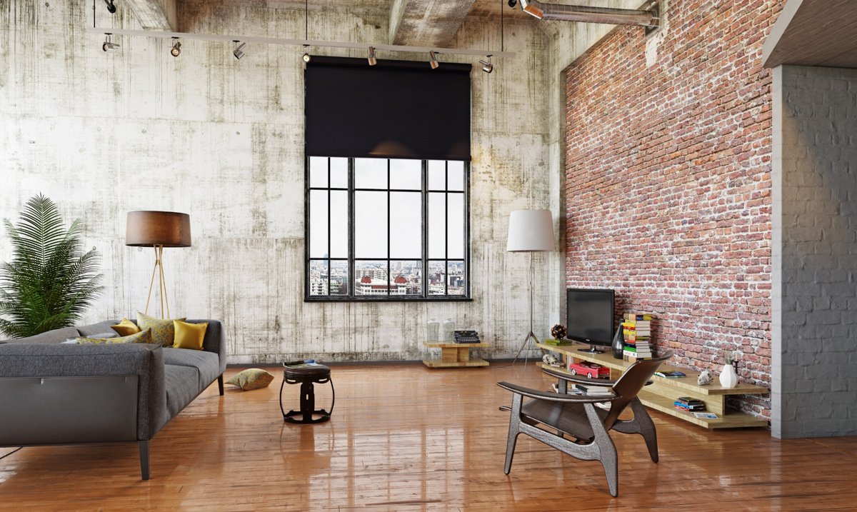 Industrial-style living room featuring exposed brick walls, a large window with a black roller blind, gray sofa with yellow cushions, wooden furniture, and polished wood flooring.