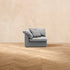 A HavenlyCloud® Couch Corner in Gray with performance fabric is centered on a wooden herringbone floor, set against a plain beige wall in the background.