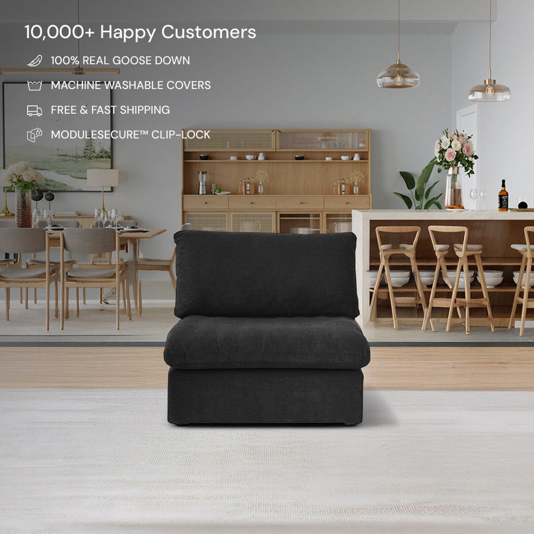 The CloudForm™ Middle Armless Modular Sofa in black, featuring removable fabric covers, is centered in a modern dining room with wooden furniture and pendant lights. Sofa features are displayed above the piece.