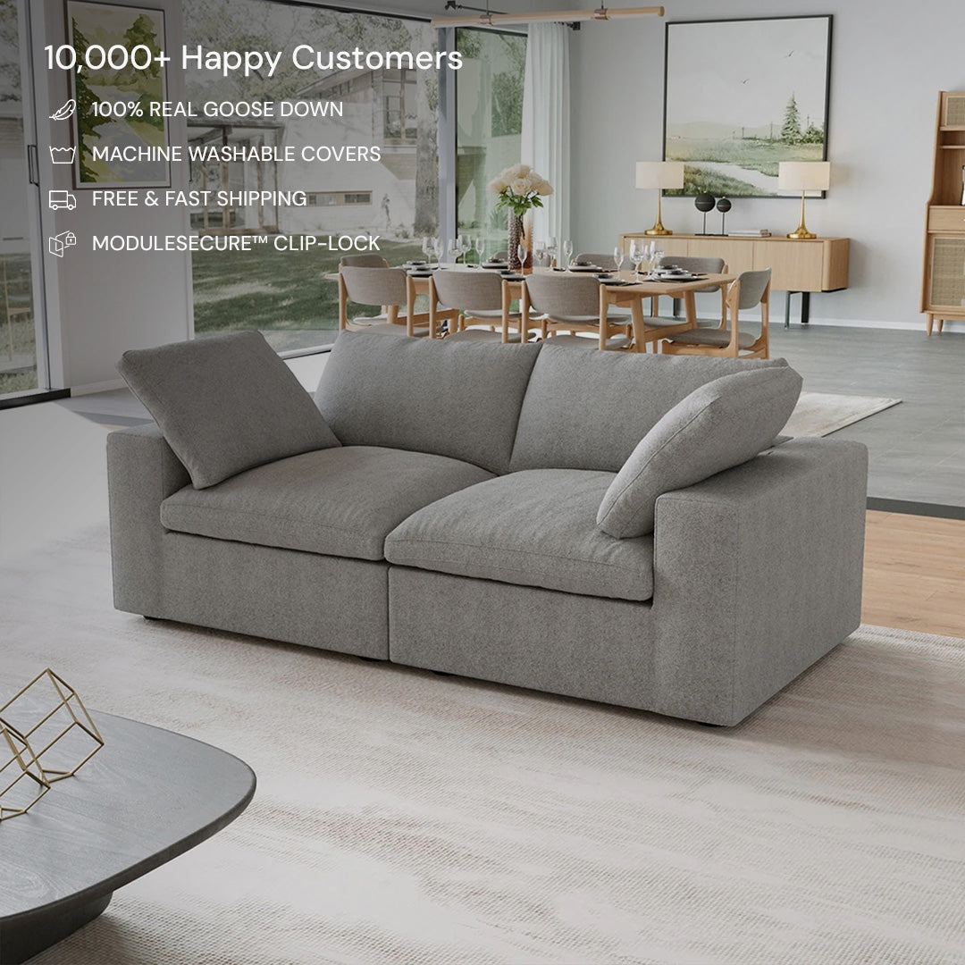A modern living room showcases the CloudForm™ 2-Seater Modular Sofa in gray with removable fabric covers, a dining table in the background, and promotional text highlighting its features and customer satisfaction.