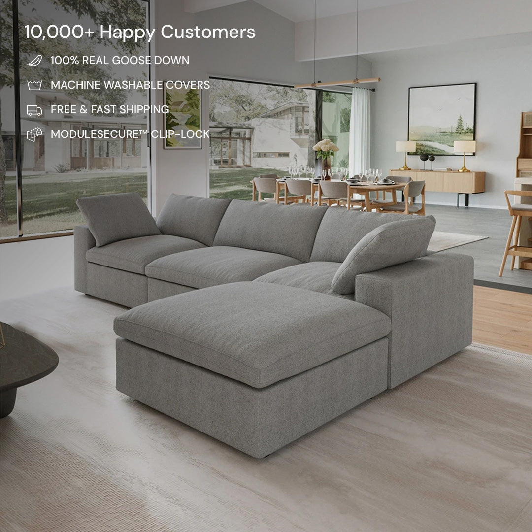 The CloudForm™ 3-Seater + Ottoman Modular Sofa in gray enhances a bright living room with large windows, wooden floors, and a dining area. Enjoy modern style, flexible modular design, and high customer satisfaction.