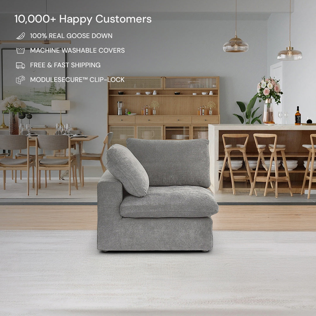A CloudForm™ Corner Modular Sofa in gray is arranged in a modern living room beside a grey armchair and a dining area with wooden furniture. Key features such as removable fabric covers are listed at the top.